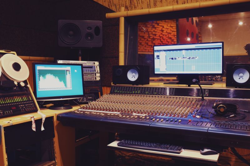 a sound recording studio with a large sound mixer and monitors